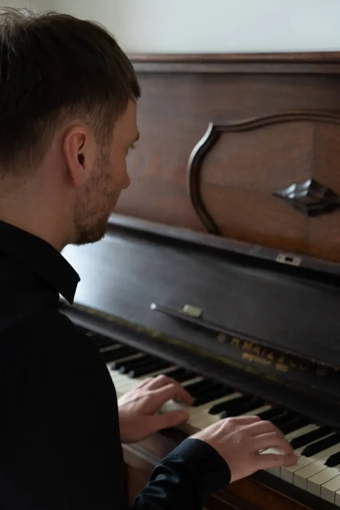 Fabian Günther im Tonstudio in Leipzig am Klavier. Kreativer Musiker bei der Arbeit an neuen Songs und Produktionen.