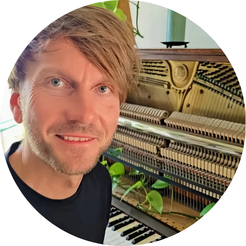 Fabian Günther sitzt am Klavier und lächelt in die Kamera Piano Künstler aus Leipzig